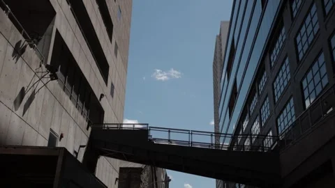 White subway train crossing elevated bridge between buildings Stock Footage 337564218