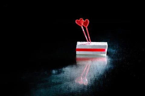 White sugar candy with layer of red marmalade and two heart shaped skewers on Stock Photos