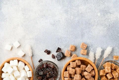 White sugar, cane sugar cubes, caramel in bamboo bowl on gray table concrete  Stock Photos