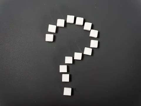 White sugar cubes arranged in the shape of a question mark Stock Photos