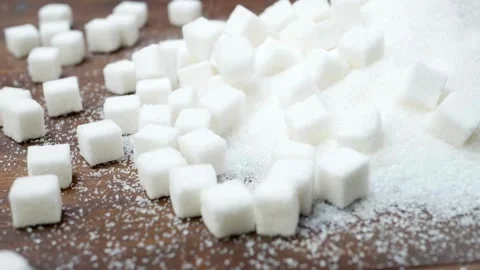 White sugar cubes falling onto a wooden table Stock-Footage 334572847