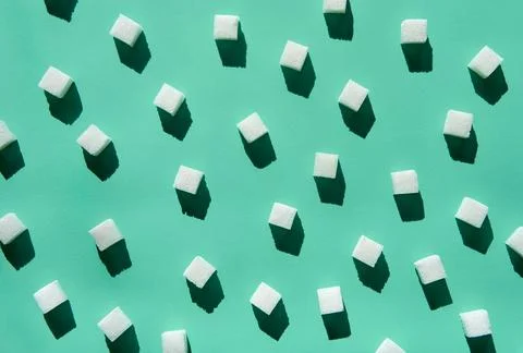 White sugar cubes pattern on green Stock Photos