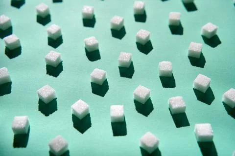 White sugar cubes pattern on green Stock Photos