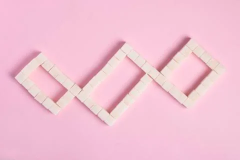 White sugar cubes on pink background. Top view. Diet unhealty sweet addiction Stock Photos