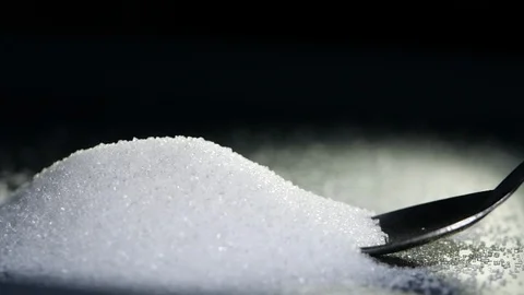 White sugar falling from tea spoon in slow motion on black background Stock Footage 115142848