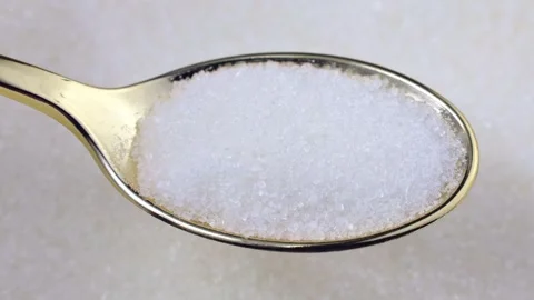 White sugar grains in the spoon with circle rotation close up Stock Footage 243094419