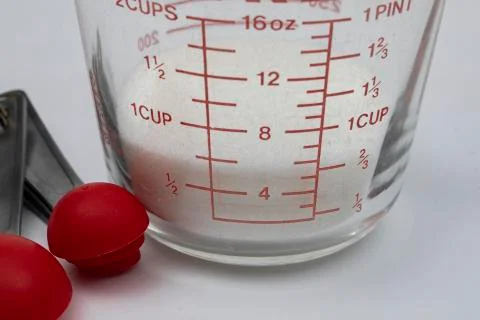 White Sugar in Measuring Cup Foto stock