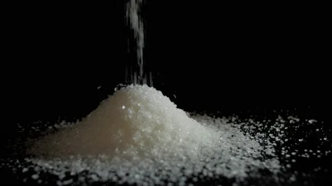 White sugar particles / crystals falling / dropped on a heap Stock Footage 158977258