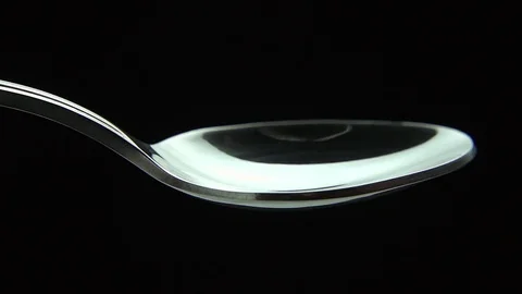 White sugar powder fall down into a spoon Vidéo 83038773