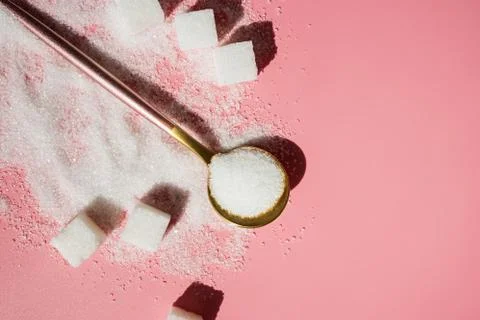 White sugar in the spoon and sugar cubes on pink Stock Photos