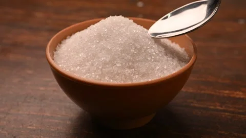 White Sugar in Spoon from Bowl on Table – Top View with  Blurred Background Stock Footage 334641399