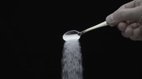 White sugar from teaspoon fall down on a black background. Slow mo Stock Footage 64703029
