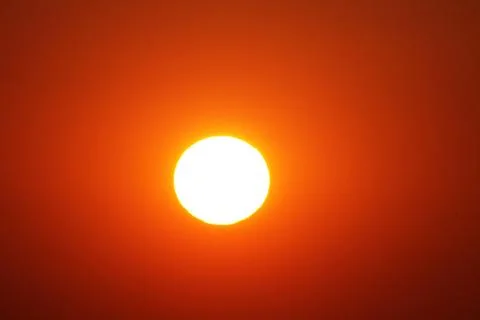 White sun in a red sky. Orange sky around the sun Stock Photos