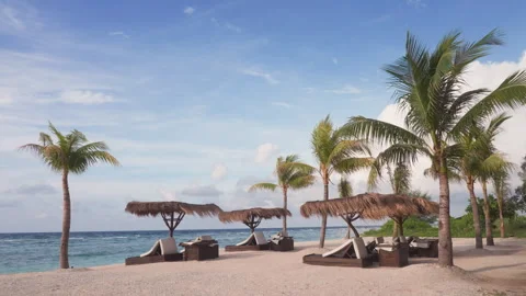 White sunbeds under beach umbrellas on luxurious resort on tropical island on Stock Footage 247189318