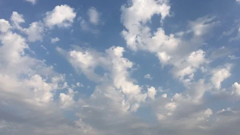 White sunset clouds disappear in the hot sun on blue sky. Loop features time lap Video stock 94472168