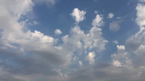 White sunset clouds disappear in the hot sun on blue sky. Loop features time lap Video stock 94472188