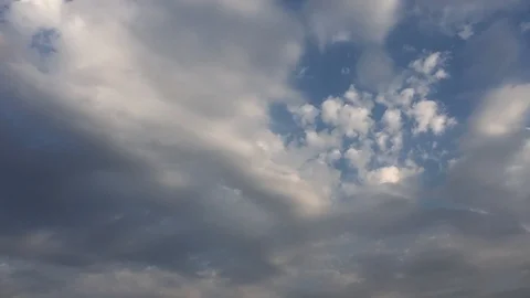 White sunset clouds disappear in the hot sun on blue sky. Loop features time lap Video stock 94472197