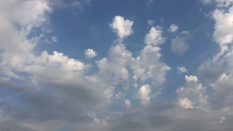 White sunset clouds disappear in the hot sun on blue sky. Loop features time lap Video stock 94472210