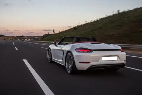 White super model cabriolet car driving on the highway in the evening Stock Photos