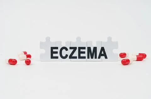 On a white surface are tablets and puzzles with the inscription - ECZEMA Stock Photos
