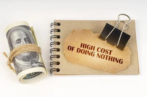 On a white surface are twisted dollars, a notebook and a cardboard sign with  写真素材
