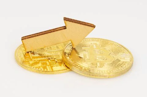 On a white surface, bitcoin and an arrow showing the growth in the value of t Stock Photos