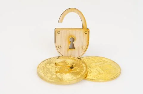 On a white surface, bitcoin and an open padlock. Stock Photos
