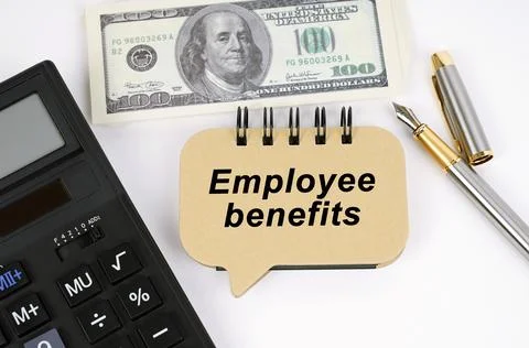 On a white surface, a calculator, dollars, a pen and a sign with the inscript Stock Photos