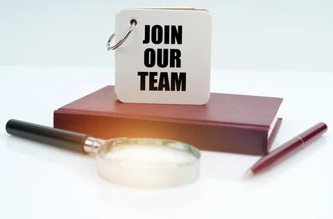 On a white surface lies a red notebook, a pen, a magnifying glass and a noteb Stock Photos