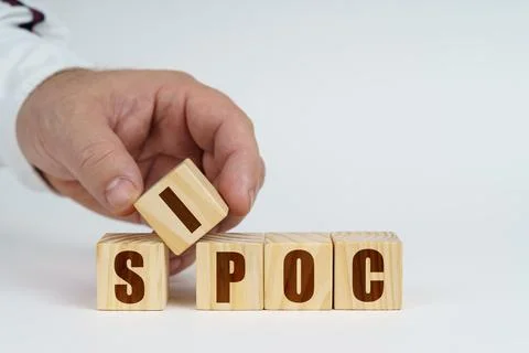 On a white surface, a man stacks cubes with the inscription - SIPOC Foto stock
