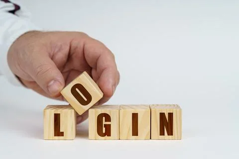 On a white surface, a man stacks cubes with the inscription - Login Stock Photos