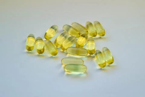 White surface with yellow tablets and capsules in the center. Mock up Stock Photos