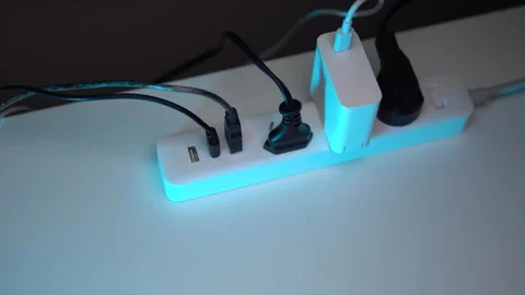 A white surge protector with three plugs and USB ports lies on the table Stock Footage 267100114