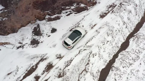 A white SUV car is driving in the mountains Video stock 269097941