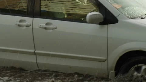 A white SUV drives through deep flood water on street. Stock Footage 338364980