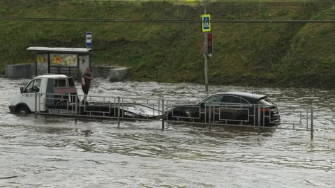 A white SUV drives through deep flood water on street. Stock Footage 338364999