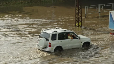 A white SUV drives through deep flood water on street. Stock Footage 338365004