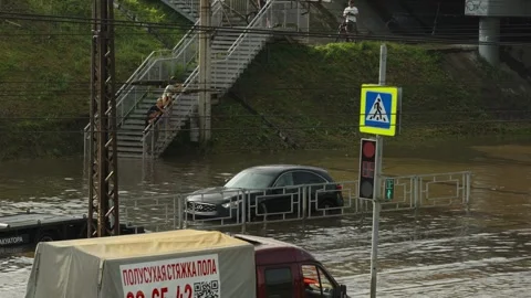 A white SUV drives through deep flood water on street. Stock Footage 338365014