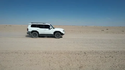 White SUV Driving Across Flat Namib Desert Plain - Aerial Side Tracking Shot Stock Footage 346540363