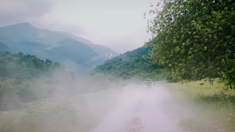 White SUV Driving to Mountain Peaks Leaving Dust Cloud Behind 库存影片 343963509