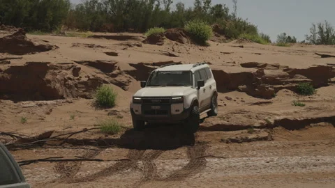 White SUV driving offroad on red sand desert terrain in Morocco Stock Footage 337912715