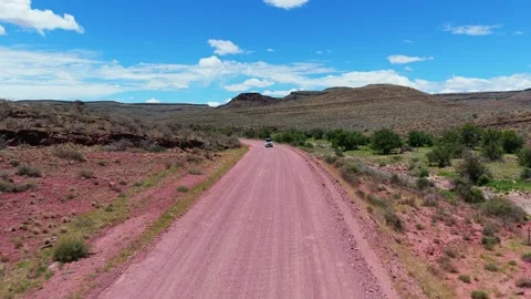 White suv driving on remote red dirt road in arid african landscape of Namibia d Stock Footage 332413737