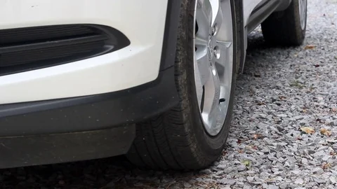 White SUV Pulls out of Rocky Driveway in Summer Time during the Day Stock Footage 78533101