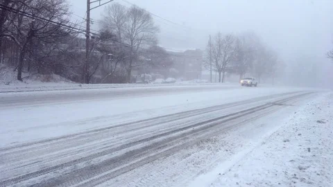 White SUV Struggles Uphill During Snowstorm With Block of Snow Under Vehicle Stock Footage 85282388