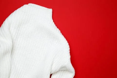White sweater displayed on a red background, simple and stylish fashion item Stock Photos