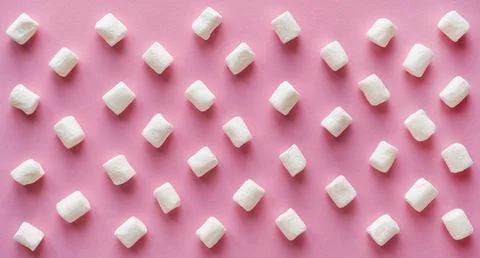 White sweet marshmallows pattern on a solid pink background 库存照片