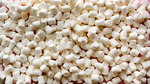 White sweet marshmallows pattern on a solid pink background Foto stock