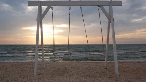  White swing against the background of the sea at sunrise Stock Footage 115498448