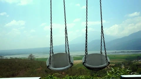 White swing with mountains in the background Stock Footage 252572733