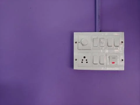 A white switch board on a violet wall Stock Photos